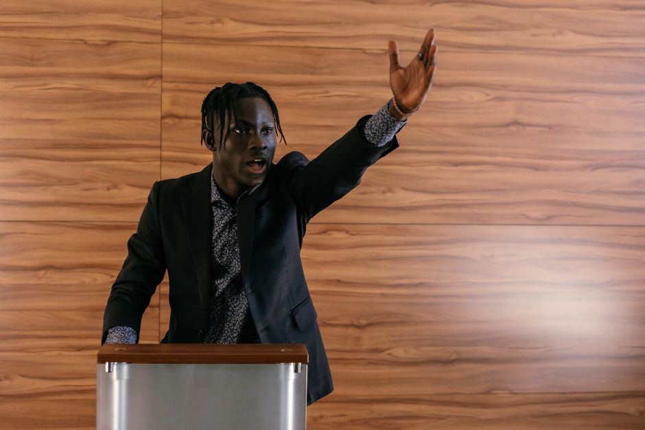 A passionate politician delivering a speech at a podium indoors.